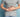 Man in grey t-shirt holding stomach in discomfort illustrating gut training for safe carb intake during running